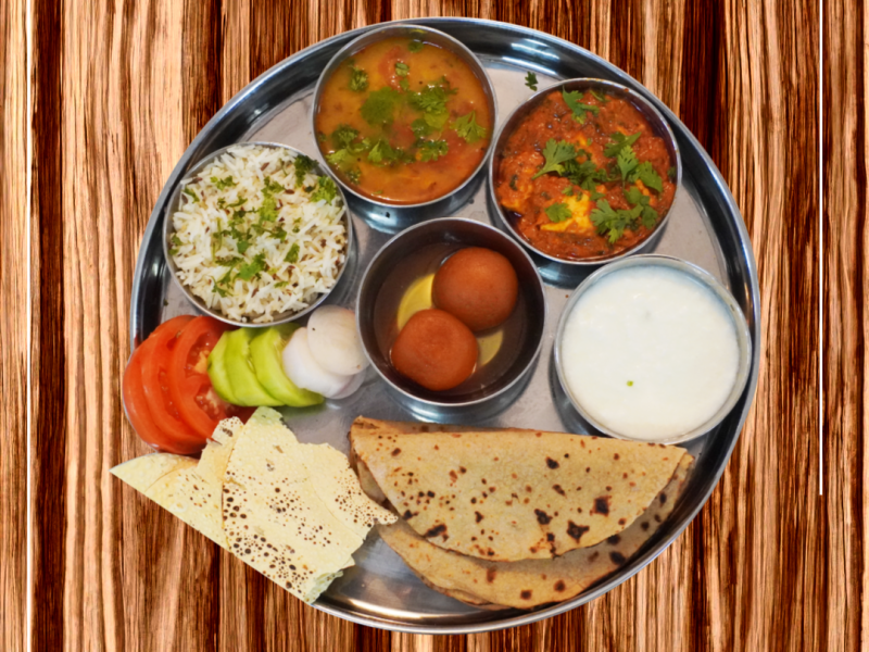 Homely Royal Feast meal plan by WarmCrave featuring roti, rice, curry, vegetables, salad, and dessert. Freshly prepared meal for tiffin service in Bhopal.